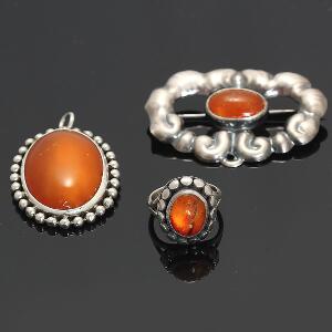 Smykkesæt bestående af ring af sterling sølv, broche og vedhæng af sølv alle prydet med cabochonslebet rav. Str. 52,5. L. ca. 4,5-5 cm. Ca. 1950. 3