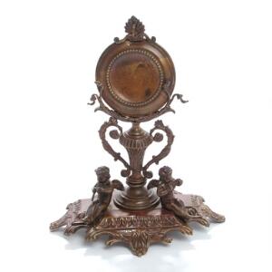 Lommeursstand af patineret metal, støbt med musicerende engle og ornamentik, vaseformet stamme. 19. årh. H. 21.
