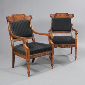 Et par fritstående senempire armstole af mahogni, rigt prydet med intarsia og skæringer, monteret i ryg og sæde med sort uld. 19. årh. 2