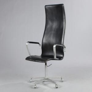 Arne Jacobsen Oxford. Højrygget kontorstol opsat på drejestel af stål monteret med hjul, betrukket med patineret sort skind.