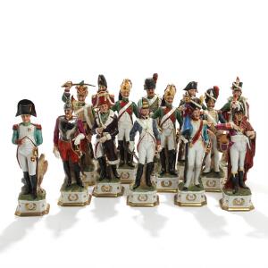 Napoleon Bonaparte med marskaller og generaler. 14 figurer af porcelæn, dekorerede i overglasur farver, guld og sølv. 20. årh. H. 31-32. 14