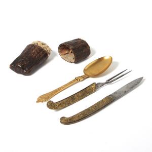 Rokoko rejse spisesæt af delvis forgyldt metal støbt med jagtscener bestående af folde kniv,ske samt gaffel i tilhørende etui af præget skind. 18. årh.