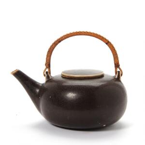 Saxbo Thekande af stentøj, dekoreret med brunlig glasur og hank af bambus beviklet med bast. H. inkl. hank 18,5.