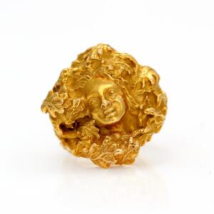 Arje Griegst Ring af 18 kt. satineret guld prydet med ansigtsmotiv. Str. 52. Vægt. 21 g.