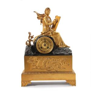Senempire kaminur af forgyldt og patineret bronze, prydet med siddende ung kvinde i klassiske gevandter. Frankrig, ca. 1840. H. 42. B. 30. D. 12.