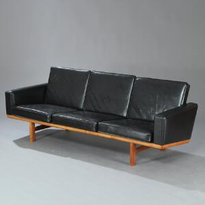 Hans J. Wegner GE 2363. Tre-pers. sofa med stel af massiv eg. Løse hynder i sæde og ryg betrukket med sort skind. Sider med sort vinyl.