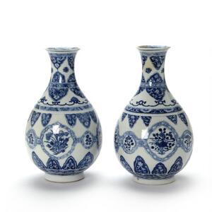 Et par pæreformede Kangxi vaser, dekorerede i underglasur blå med blomster i felter og borter. Kina 1662-1722. H. 29 cm. 2