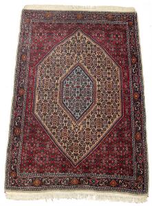 Bidjar tæppe, prydet med klassisk kantet medaljondesign på rød bund. Persien. Ca. 1990. 172 x 112.