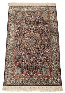 Indisk Kashmir tæppe, silke på uld, prydet med ornamentik, blomster og bladværk på blå bund. Ca. 1980. 154 x 92.