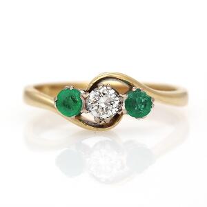 Smaragd- og diamantring af 18 kt. guld prydet med brillantslebet diamant flankeret af facetslebne smaragder. Str. 54,5. Ca. 1980.