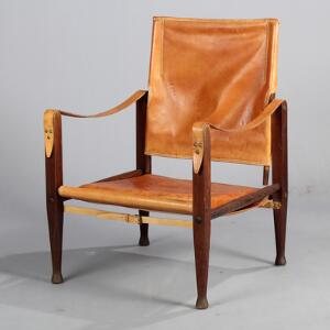 Kaare Klint Safari stol. Lænestol med stel af mørkbejdset træ, sæde og ryg med betræk af cognacfarvet skind. Udført hos Rud. Rasmussen.