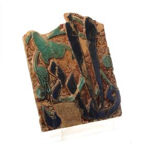 Iransk relief af brændt ler, dekoreret i farver med skrifttegn. Iran, 13.-14. årh. Sammensat.