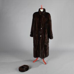 Frakke af mørkebrun mink med to knapper og hægtelukning samt to stiklommer. L. 125. Samt pandebånd af mink. 2
