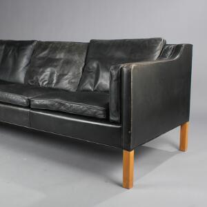 Børge Mogensen Fritstående tre-personers sofa med sort patineret skind, ben af kirsebærtræ. Udført hos Fredericia Furniture. L. 222.