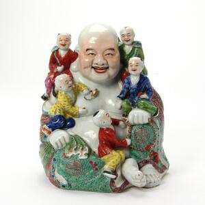 Kinesisk figur af porcelæn dekoreret i farver i form af Budai med fem børn, indprentet mærke i bund. 20. årh. H. 28 cm.