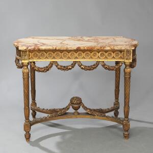 Fritstående bord af forgyldt træ, med plade af marmor. Louis XVI form, 20. årh.s begyndelse. H. 76. B. 100. D. 61.