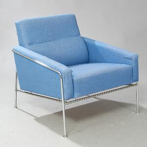Arne Jacobsen Lufthavnsstol. Lænestol med stel af forkromet stål, sæde, ryg og armlæn overpolstret med lys blå uld. Model 3301.