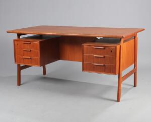 Gunni Omann Fritstående skrivebord af teak med svævende plade, front med seks skuffer, bagside med rum og skab. H. 73. L. 154. B. 81.