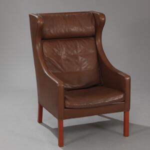 Børge Mogensen Øreklapstol med ben af mahogni. Sider samt hynder i sæde, ryg og nakke betrukket med brunt farvet skind. Model 2204.