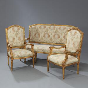 Sofa samt to armstole af forgyldt træ, prydet med skæringer i form af blomster og akantus, kannelerede ben. Louis XVI form. 20. årh. Sofa L. 166. 3