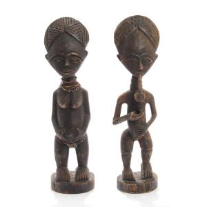 Et par afrikanske Akan tvillingefigurer af udskåret, patineret træ, heraf den ene dekoreret med perlekæder. Ghana. 20. årh. H. 46. 2