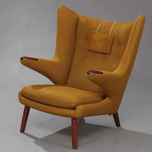 Hans J. Wegner Bamsestol. Øreklapstol med ben og negle af teak, betrukket med grøngul uld. Udført hos AP-Stolen.