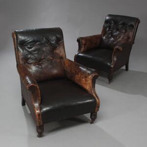 Et par lænestole med ben af mørkbejdset bøg. Betrukket med brunt, patineret skind. 20. årh.s begyndelse. 2