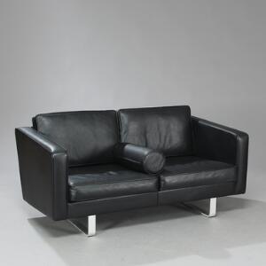 Søren Holst Fritstående to-personers sofa med stel af aluminium. Sider, ryg samt løse hynder betrukket med sort skind.