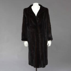 Saga Mink Lang pelsfrakke af mørkebrun minkpels med lommer. Str. 38-40, L. ca. 118 cm.