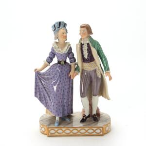 Figur af porcelæn i form af spadserende par, dekoreret i overglasurfarver. Juliane Maries mærke. Royal Copenhagen. H. 20,5 cm.