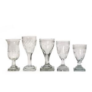 En samling Louis XVI og empire hedvinsglas i varierende former, alle med firsidet fod. H. 10,5- 14 cm. 21