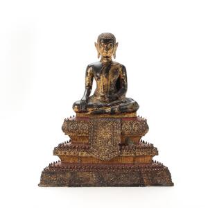 Thailandsk buddha af delvis forgyldt bronze siddende i bhumisparsa på tredelt lotustrone dekoreret med glasstene. C. 1900. H. 47 cm.