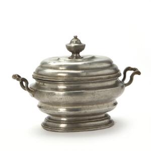 Oval empire terrin af tin, lågknop i form af urne. Utydelige mærker. 19. årh.s første halvdel. H. 20 cm. L. 29 cm.