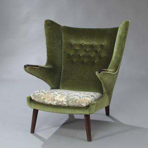 Hans J. Wegner Bamsestol. Lænestol med ben af bejdset bøg, negle af nød. Sider og ryg betrukket med grøn plys, sæde med blomstret stof.