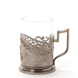 Finsk theglas-holder af sølv, dekoreret med monogram i guld og graveret med inskription med kyrilliske bogstaver. 1910. Vægt ca. 248. H. 11,5.