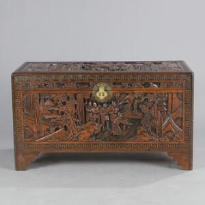 Orientalsk kiste af kamfertræ, rigt udskåret med figurer i landskaber og ornamentik. 20. årh. H. 57. L. 104. B. 54.