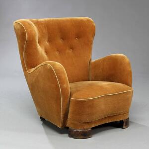 Flemming Lassen, stil Overpolstret lænestol betrukket med gulbrun velour, dybthæftet ryg. Ben af mørkpoleret bøg.