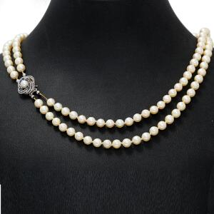 Dobbeltradet perlehalskæde med talrige kulturperler og perle-og safirlås af 14 kt. hvidguld prydet med facetslebne safirer og kulturperle. L. ca. 48 cm.