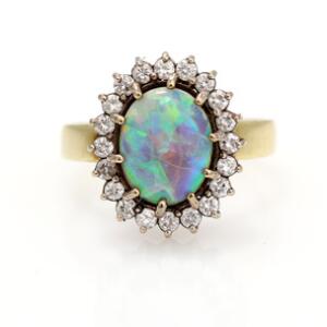 Opal-og diamantring af 14 kt. guld prydet med cabochonslebet opal omkranset af talrige brillantslebne diamanter. Str. 53.