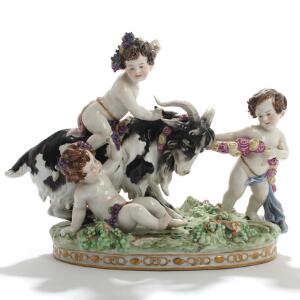 Putti med ged. Figurgruppe af porcelæn, rigt modelleret med pousserede blomster og dekoreret i overglasurfarver. Wien, 20. årh. H. 24,5.