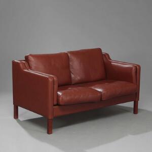 Dansk møbeldesign Fritstående to-personers sofa med ben af bejdset bøg. Sider, ryg samt løse hynder betrukket med brun skind.
