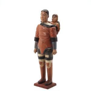 Johannes Kreutzmann Grønlandsk dukke af bemalt og udskåret træ i form af inuit kvinde med barn. Usign. H. 42 cm.