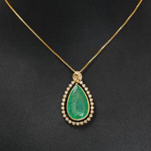 Smaragd- og diamantvedhæng med tilhørende kæde af 18 kt. guld prydet med stor oval facetslebet smaragd omkranset af talrige brillantslebne diamanter.