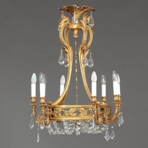 Fransk lysekrone af forgyldt bronze, monteret med prismekæder og bund af matteret glas. Louis XVI stil, 19. årh.s slutning. H. 85. Diam. 65.