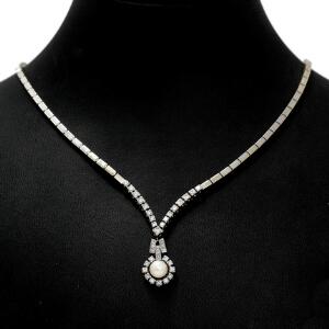 Perle- og diamanthalskæde af 14 kt. hvidguld prydet med kulturperle og talrige brillantslebne diamanter. L. ca. 52 cm. Æske medfølger. Ca. 1960.