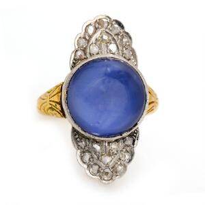 Iolit- og diamantring af 14 kt. guld og hvidguld prydet med cabochonslebet stjerneiolit flankeret af talrige rosenslebne diamanter. Str. 55.