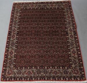 To persiske tæpper. Sherkat Bidjar, gentagelsesmønster med heratimønster på rød bund. 239 x 173. Afshar, sammenhængende hagemedaljoner. 225 x 158.