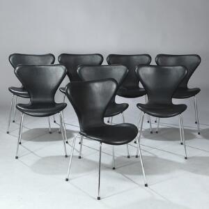 Arne Jacobsen Syveren. Et sæt på otte stole med ben af forkromet stål. Sæde og ryg af formbøjet krydsfinér betrukket med sort skind. 8