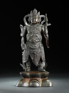 Skanda, Wei Tuo af patineret bronze stående med løftet hånd med stupa, iklædt dragt med dyrehoved på hver skulder. Ming 1368-1644. H. 35 cm.