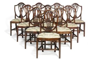 Et sæt på tolv Engelske stole, heraf to armstole, af mahogni i Hepplewhite design. 18. årh.s slutning. Fire stk. nyeligt fremstillet. 12